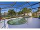 Pool area with a uniquely shaped pool, screened enclosure, and a view of the backyard and shed at 1543 Reade Cir, St Cloud, FL 34772