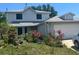 Charming two-story home with an attached garage and a welcoming front yard filled with plants at 172 Pinewood Cir, Kissimmee, FL 34743