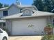 Attached two car garage with a brick facade, situated beneath an interesting roofline at 172 Pinewood Cir, Kissimmee, FL 34743