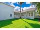 Large manicured backyard with covered patio, lush green grass, and palm trees at 204 Celebration Blvd, Celebration, FL 34747
