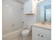 Clean bathroom with white tile, vanity, sink, toilet, and shower at 204 Celebration Blvd, Celebration, FL 34747