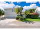 Two-story home with a three car garage and lush tropical landscaping at 204 Celebration Blvd, Celebration, FL 34747