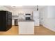 Well-lit kitchen with white cabinets, island, black appliances, and a washer/dryer at 204 Celebration Blvd, Celebration, FL 34747