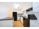 Updated kitchen featuring black appliances, white cabinets, an island and in-unit laundry at 204 Celebration Blvd, Celebration, FL 34747