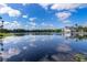 Scenic lakeside view with clear water reflecting the sky and buildings in the distance at 204 Celebration Blvd, Celebration, FL 34747
