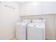 Clean laundry room with white washer and dryer, plus overhead storage cabinets at 204 Celebration Blvd, Celebration, FL 34747