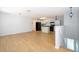 Open-concept living room with wood floors and white kitchen featuring black appliances at 204 Celebration Blvd, Celebration, FL 34747