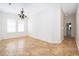An airy living room features two bright windows, chandelier, and hallway to the bathroom at 204 Celebration Blvd, Celebration, FL 34747