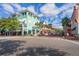 Scenic street with colorful buildings, palm trees, and pedestrian crosswalks under a blue sky at 204 Celebration Blvd, Celebration, FL 34747
