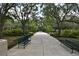 Scenic walking path with benches lined with lush greenery, great for leisurely strolls and enjoying nature at 204 Celebration Blvd, Celebration, FL 34747
