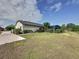 Expansive backyard featuring lush green grass, a screen enclosed pool, and mature landscaping at 2150 Emperor Dr., Kissimmee, FL 34744