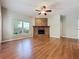 Bright living room featuring hardwood floors, a ceiling fan, a brick fireplace, and a large window at 2150 Emperor Dr., Kissimmee, FL 34744