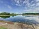 Reflective pond showcasing sky and tree line, enhancing the natural beauty of the landscape at 2150 Emperor Dr., Kissimmee, FL 34744