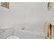 Bright bathroom featuring a white tiled tub and toilet at 2473 Saint Augustine Blvd, Haines City, FL 33844