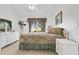 Bright bedroom featuring plush bedding, white furniture, and a window overlooking a green space at 2473 Saint Augustine Blvd, Haines City, FL 33844