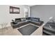 Modern living room with a sleek black leather sectional sofa, contemporary decor, and natural light at 2628 Tranquility Way, Kissimmee, FL 34746