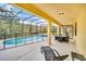 Relaxing screened-in pool area with a hot tub, a lounge chair, and a table with chairs at 2628 Tranquility Way, Kissimmee, FL 34746