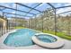 Sparkling swimming pool and hot tub surrounded by a screened enclosure, offering a private oasis at 2628 Tranquility Way, Kissimmee, FL 34746