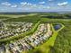 Aerial image displays houses in a residential area near trees and water features with blue sky and clouds at 3138 Dark Sky Dr, St Cloud, FL 34773