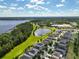 Expansive aerial shot showcases a neighborhood, lake, and lush greenery under a partly cloudy sky at 3138 Dark Sky Dr, St Cloud, FL 34773