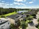 Beautiful aerial view of suburban homes, a tranquil pond, and green spaces under a bright, partly cloudy sky at 3138 Dark Sky Dr, St Cloud, FL 34773