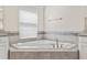 Close-up view of soaking tub with tiled surround and brushed gold fixtures at 3138 Dark Sky Dr, St Cloud, FL 34773