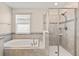 Bright bathroom with a tub, tiled walk-in shower, and large window at 3138 Dark Sky Dr, St Cloud, FL 34773
