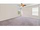 Spacious bedroom with neutral carpet, ceiling fan and natural light from two windows at 3138 Dark Sky Dr, St Cloud, FL 34773