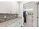 Charming butler's pantry with granite countertops, sleek mosaic tile backsplash, and ample storage at 3138 Dark Sky Dr, St Cloud, FL 34773