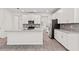 Modern kitchen features white cabinets, a large center island, granite countertops, and wood-look floors at 3138 Dark Sky Dr, St Cloud, FL 34773