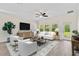 Bright living room featuring wood floors, a cream sofa, large TV, and natural light at 3138 Dark Sky Dr, St Cloud, FL 34773