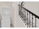 Staircase with carpet and iron railing next to a stacked washer/dryer at 3138 Dark Sky Dr, St Cloud, FL 34773