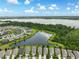 Scenic aerial view showcasing homes adjacent to a beautiful lake, surrounded by lush trees and greenery at 3428 Sagebrush St, St Cloud, FL 34773