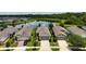 Aerial view featuring well-maintained homes with attached garages and neatly manicured lawns near a pond at 3428 Sagebrush St, St Cloud, FL 34773