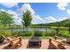 Charming backyard patio with adirondack chairs and a fire pit for cozy evenings, lake in the background at 3428 Sagebrush St, St Cloud, FL 34773