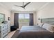 Light and airy bedroom with a ceiling fan, a large window overlooking a green landscape, and decorative accents at 3428 Sagebrush St, St Cloud, FL 34773