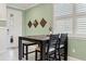 Cozy dining area with light green wall, stylish wood table, and a view to the front entrance through the window at 3428 Sagebrush St, St Cloud, FL 34773