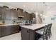 Modern kitchen with dark cabinets, quartz countertops, stainless steel appliances, and center island seating at 3428 Sagebrush St, St Cloud, FL 34773