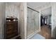 A walk-in shower is adjacent to a wooden dresser for accessible bathroom storage at 402 Ohio Way, Kissimmee, FL 34759
