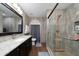 The bathroom features a granite sink, wall mirror, and glass shower with neutral tones at 402 Ohio Way, Kissimmee, FL 34759