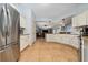 Spacious kitchen with white cabinets and stainless steel appliances leading to living room at 402 Ohio Way, Kissimmee, FL 34759