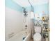 Bright bathroom with a shower-tub combination, white tile, and ample storage on wall shelves at 4403 S Semoran Blvd # 2, Orlando, FL 32822
