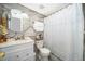 Stylish bathroom with a circular mirror, a white vanity, and a tiled shower with patterned shower curtain at 4403 S Semoran Blvd # 2, Orlando, FL 32822