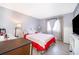 Comfortable bedroom with a bed, dresser, television, and a well-lit window providing ample natural light at 4403 S Semoran Blvd # 2, Orlando, FL 32822