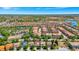 Beautiful aerial view of a neighborhood with houses with red roofs, lush trees, and a tranquil lake at 4416 Acorn Ct, Davenport, FL 33837