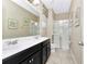 This bathroom offers a double vanity, a glass-enclosed shower, and neutral tones for a modern feel at 4416 Acorn Ct, Davenport, FL 33837