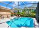 Inviting screened-in pool with a hot tub, lounge chairs, and tropical landscaping for ultimate relaxation at 4416 Acorn Ct, Davenport, FL 33837