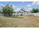 Spacious backyard with a large lawn, trees and a white fence at 4420 Lake Lawne Ave, Orlando, FL 32808