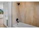 Bathroom featuring tiled walls, tub, and modern fixtures at 4420 Lake Lawne Ave, Orlando, FL 32808