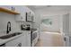 Bright kitchen featuring white cabinets, stainless steel appliances, and a view to the outside at 4420 Lake Lawne Ave, Orlando, FL 32808